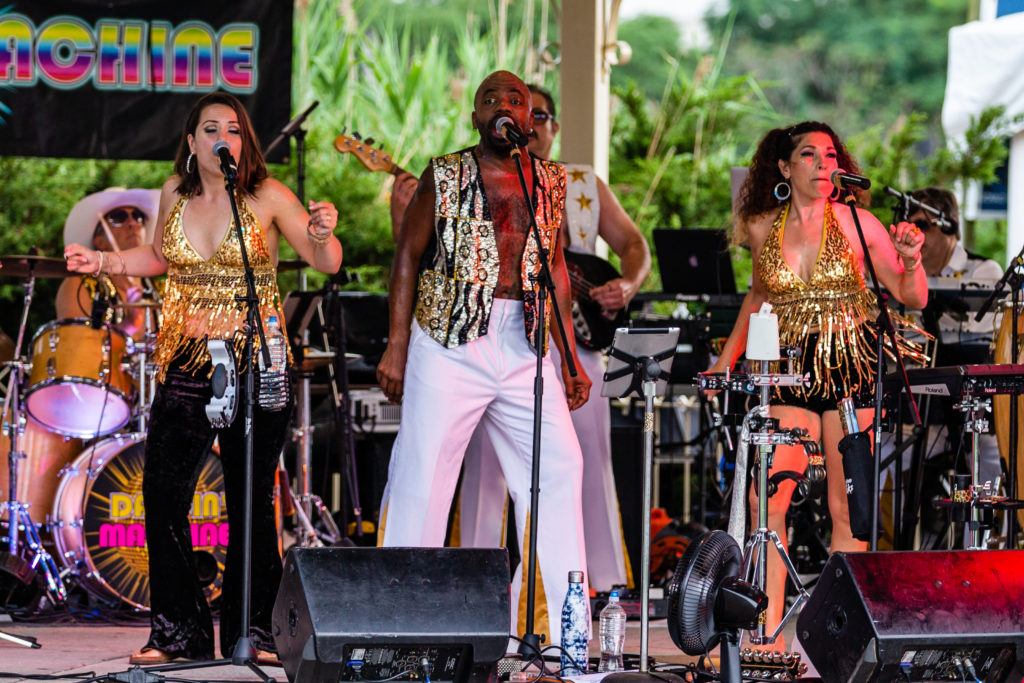 A group of people performing on stage with one man singing.